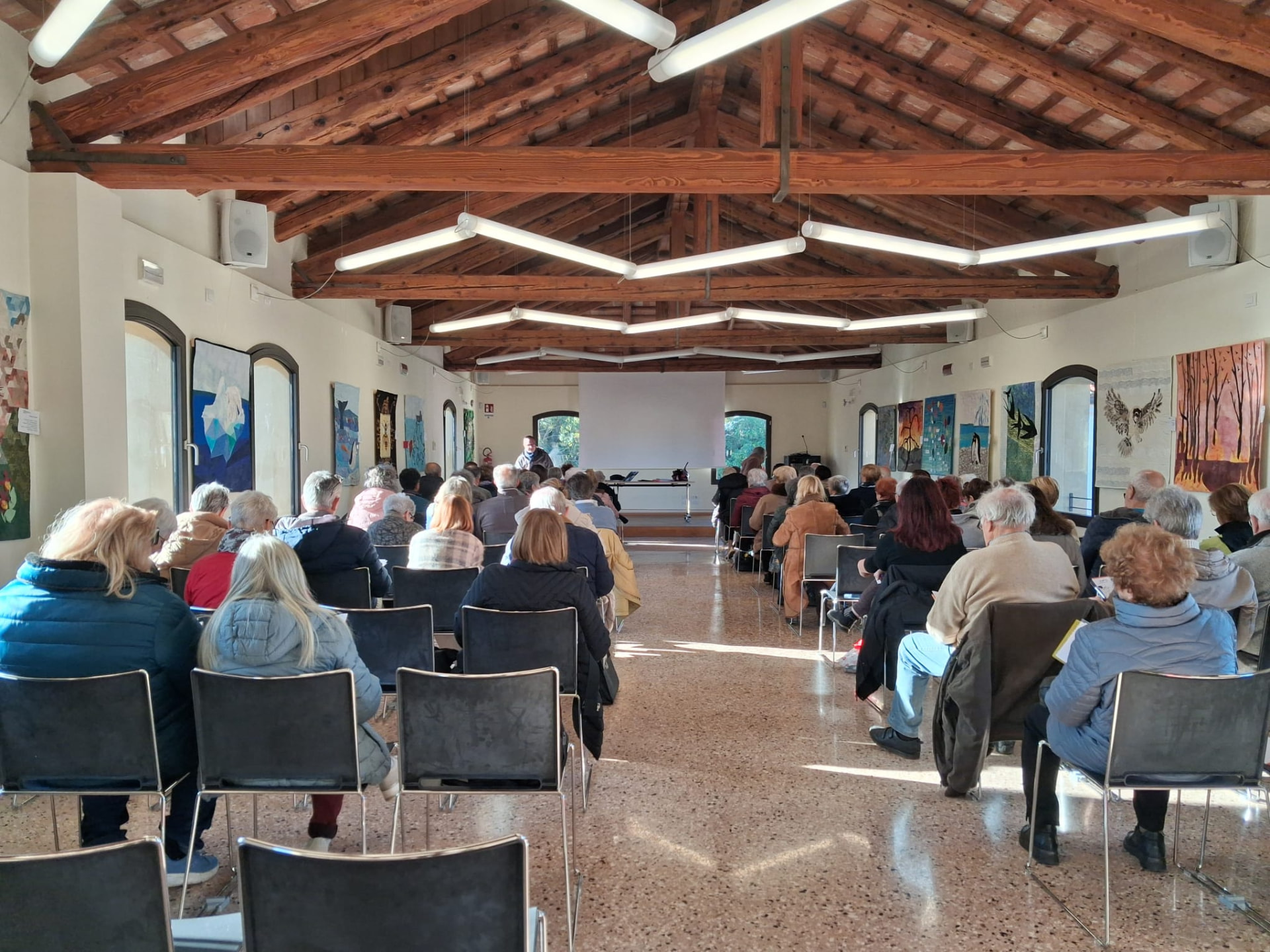 Sala piena di partecipanti durante una lezione nella sede di Paese